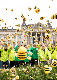 BUND-Aktive werfen Hunderte gehäkelte Bienen in die Luft.
